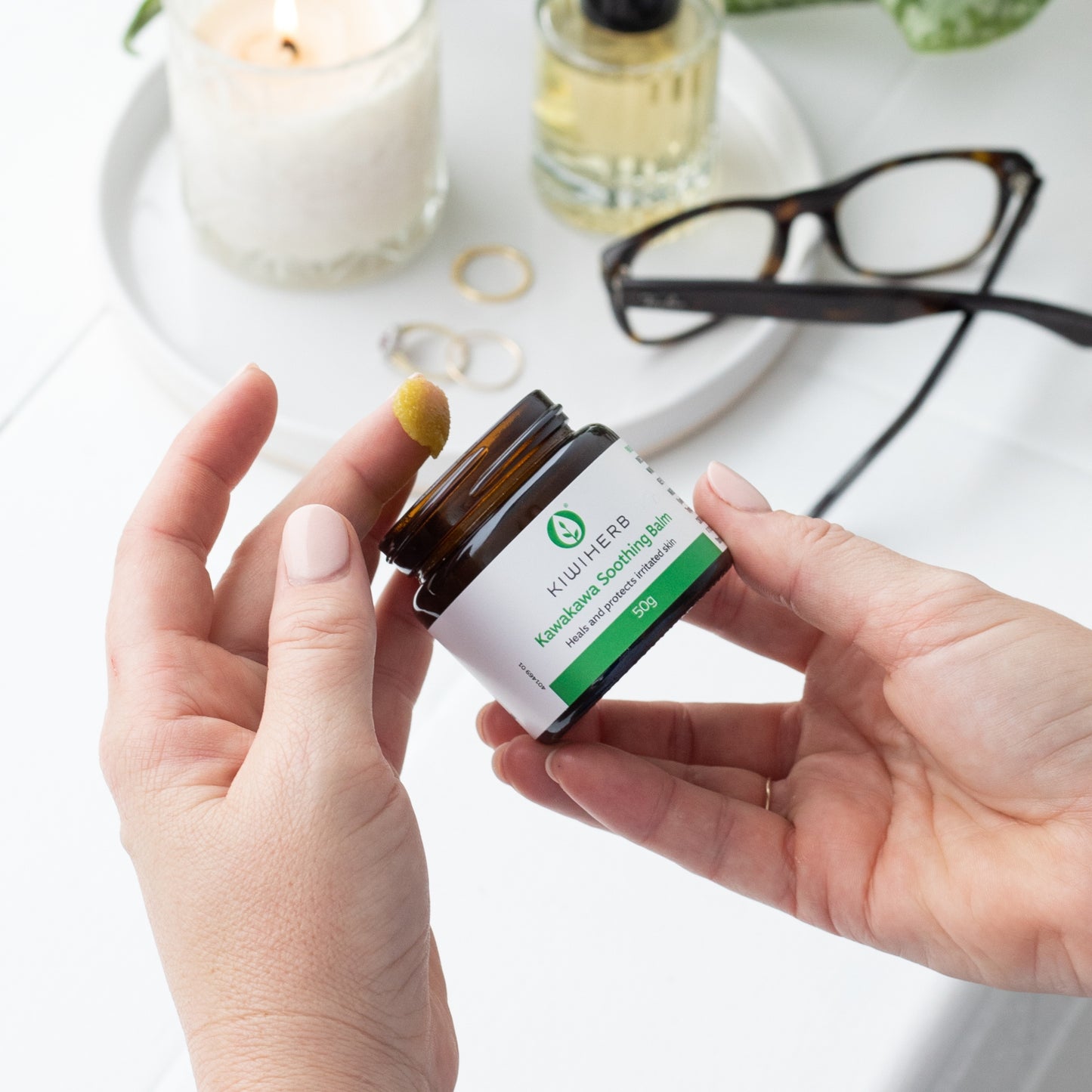 A woman's hand showing Kawakawa Soothing Balm.