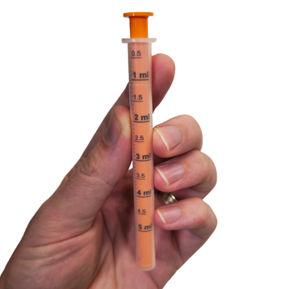 kiwiherb 5mL dosage syringe being held against a white background.