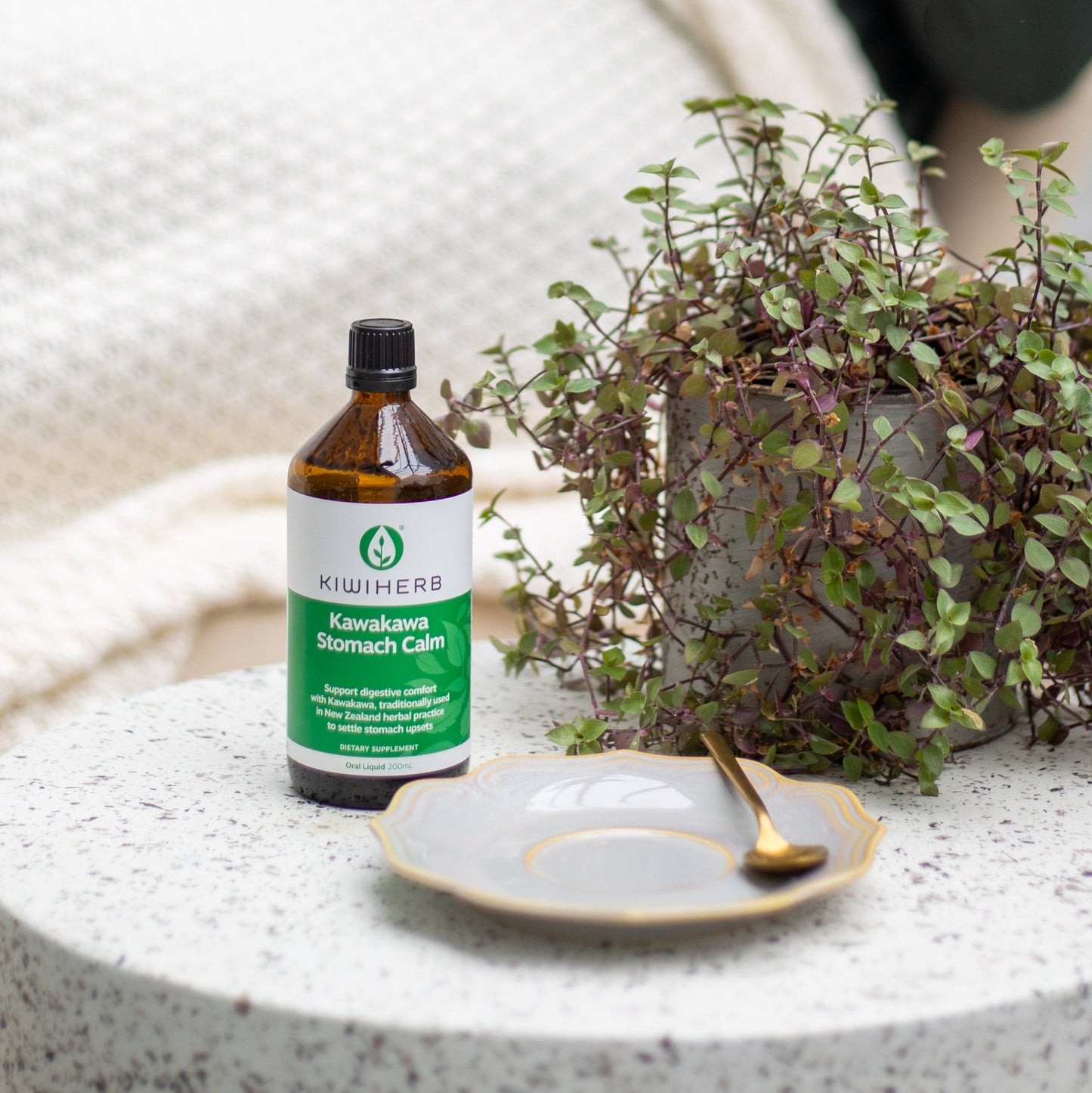 Kawakawa Stomach Calm bottle with woman behind