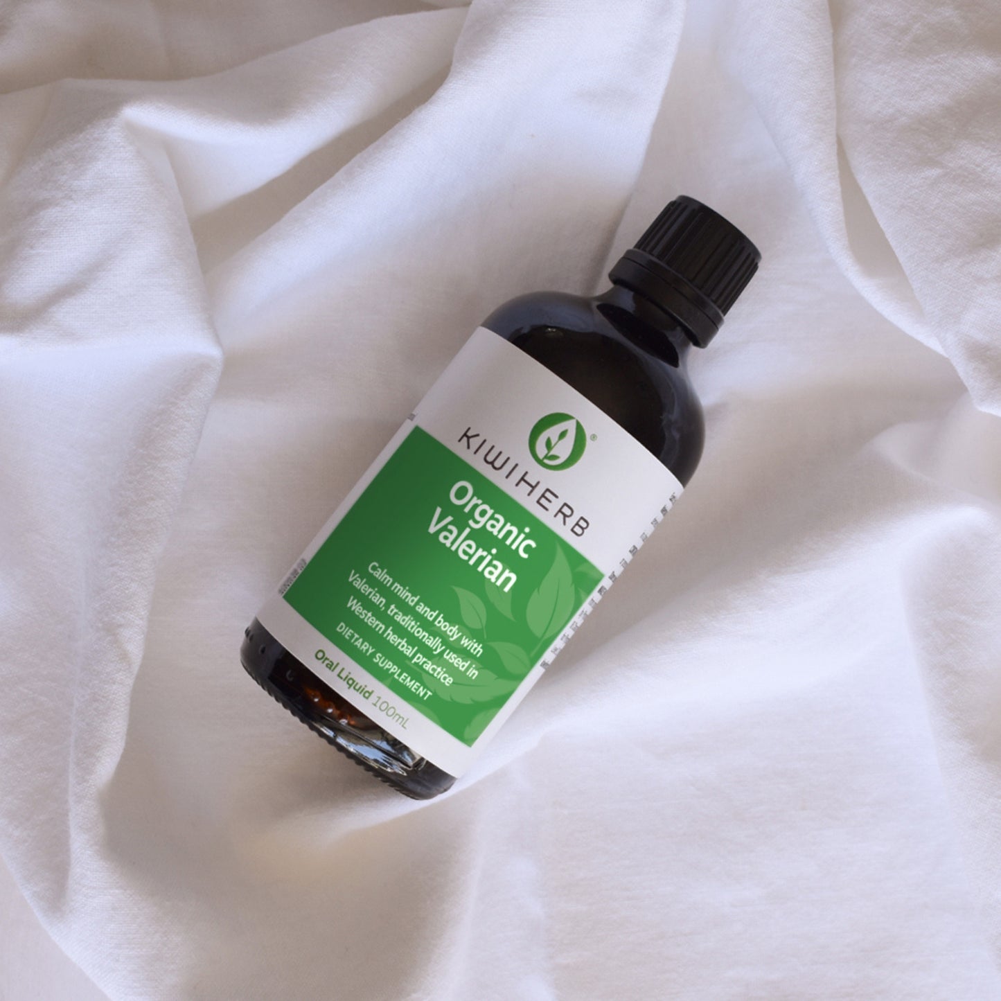 A bottle of Organic Valerian on white sheets.